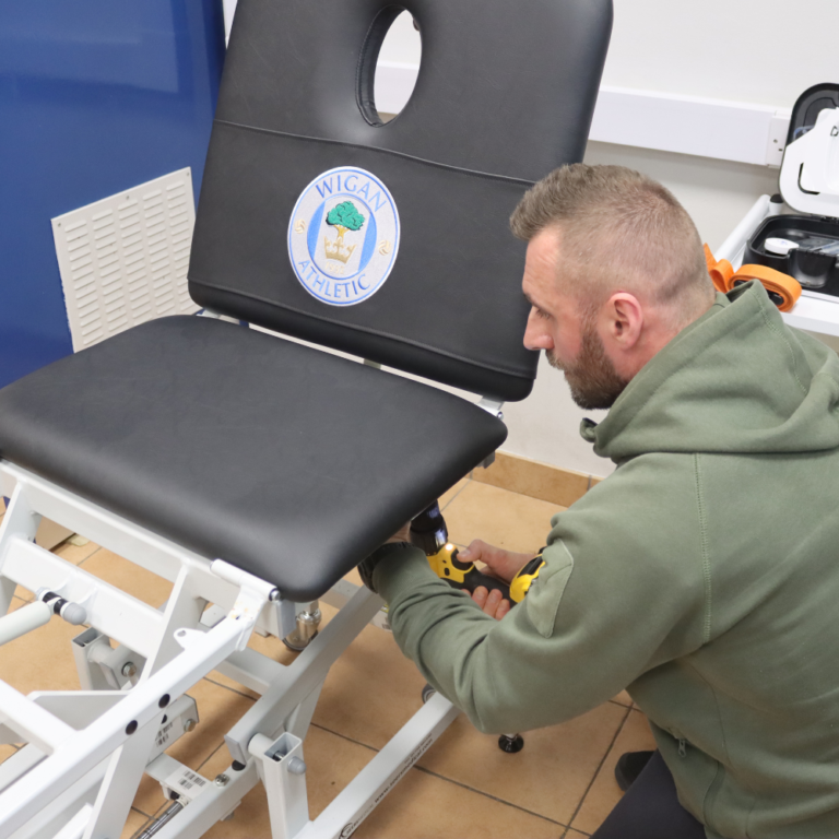 Upholsterer repairing physio bed at Wigan Athletic Football Club