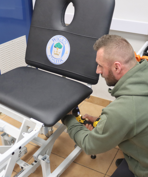 Upholsterer repairing physio bed at Wigan Athletic Football Club